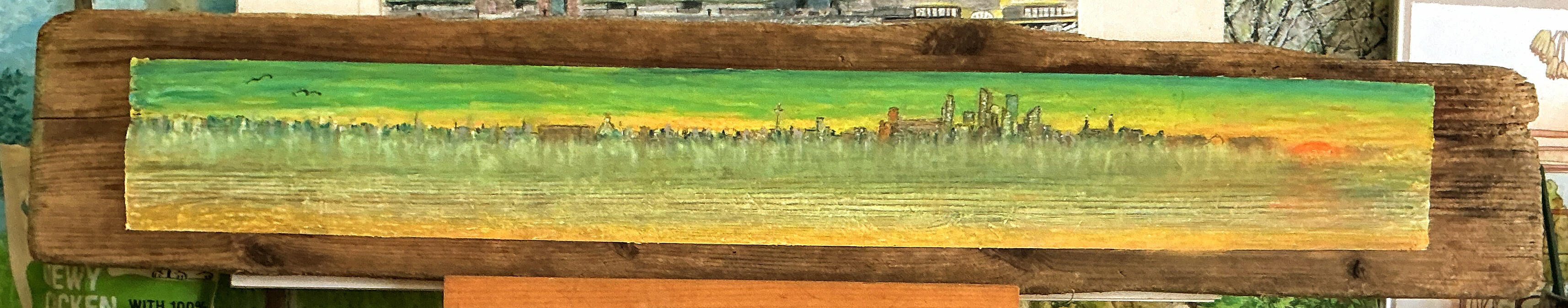 The Liverpool Waterfront 2025. As seen from Wirral. Oil pastels on Irish Sea driftwood